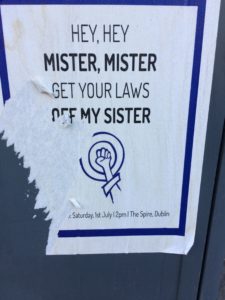 Photo of a poster that reads Mister, Mister Get your laws off my sister, above an image of the woman's symbol with a fist at the center
